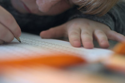 Cropped image of boy doing homework at home