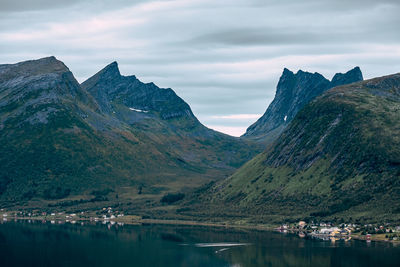 Scenic view of lake by mountains against sky