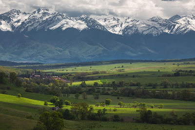 Scenic view of field and mountains against sky