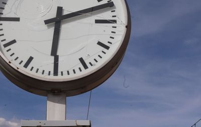 Low angle view of clock against sky