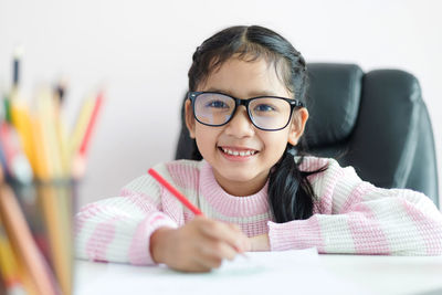 Portrait of girl sitting on table