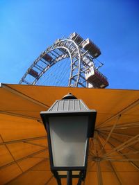 Low angle view of ferris wheel against building