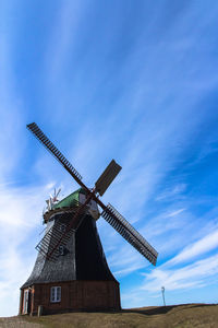 Low angle view of traditional windmill against sky