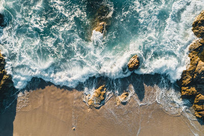 High angle view of waves breaking on rocks