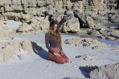 Low section of woman standing at beach