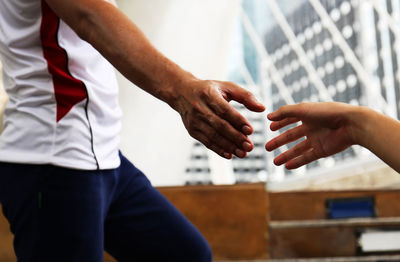 Midsection of couple holding hands