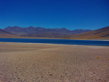 Scenic view of desert against clear blue sky