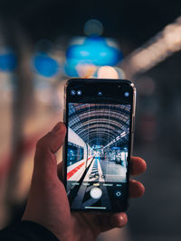 Cropped image of man photographing through smart phone