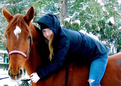 Portrait of young woman with horse