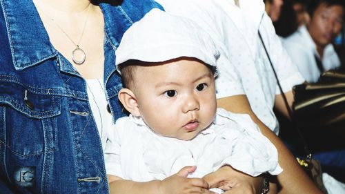 Cute baby looking away with mother and father