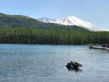 Scenic view of lake by mountain against clear sky