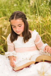 Portrait of young woman sitting on field