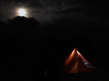 Illuminated tent against sky at night