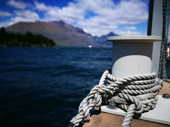 Cropped image of bollard with rope by lake