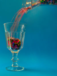 Close-up of wine glass on table against blue background