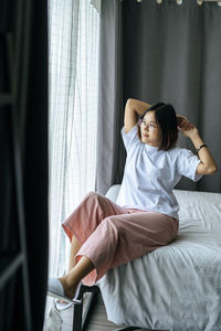 Young woman resting on bed at home
