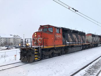 Train on railroad tracks against sky during winter