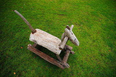 High angle view of wooden rocking horse on field at playground