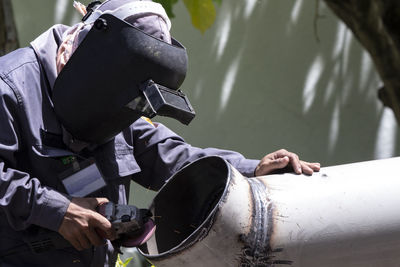 Close-up of man cutting pipe