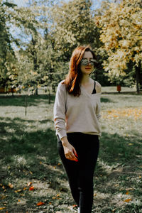 Portrait of young woman standing on field