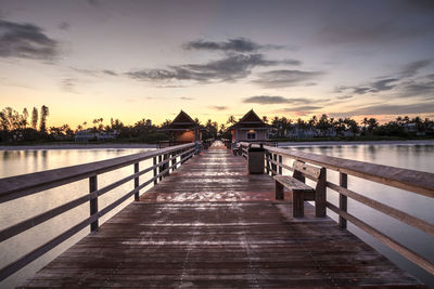 Pier over lake against sky during sunset