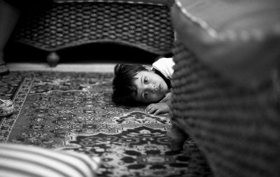 Portrait of cute boy lying on carpet at home