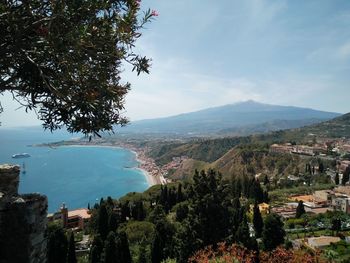 Aerial view of townscape by bay against sky