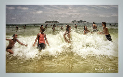 People enjoying in sea against sky