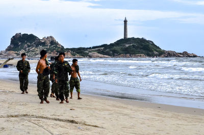 People on beach against sky