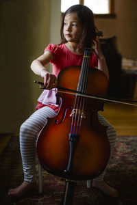 A little girl with barefoot practices cell on her living room