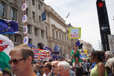 People on street against buildings in city