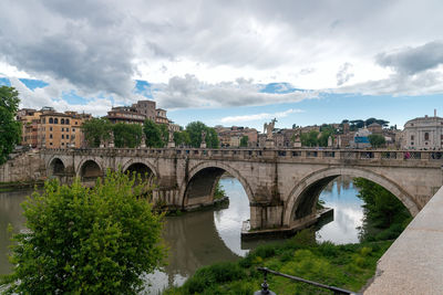 Arch bridge over river against sky