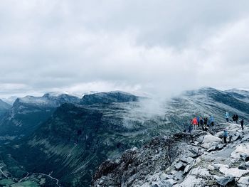People on snowcapped mountain against sky