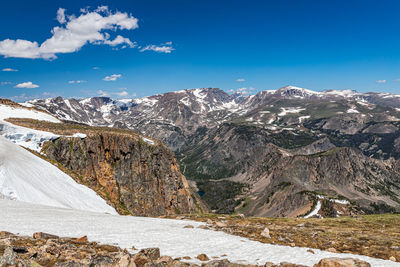 Scenic view of snowcapped mountains against blue sky