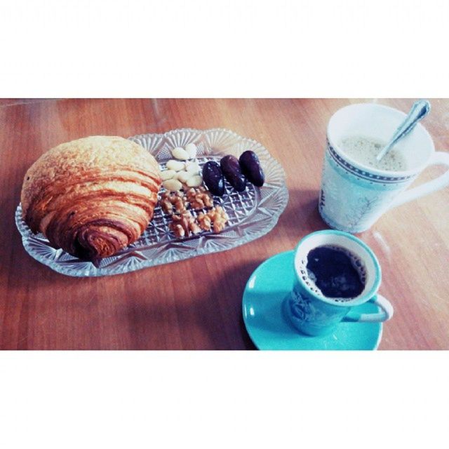 food and drink, transfer print, indoors, table, still life, drink, freshness, refreshment, auto post production filter, food, high angle view, coffee cup, drinking glass, wood - material, coffee - drink, spoon, close-up, plate, cup, directly above