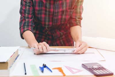 Midsection of man reading book on table