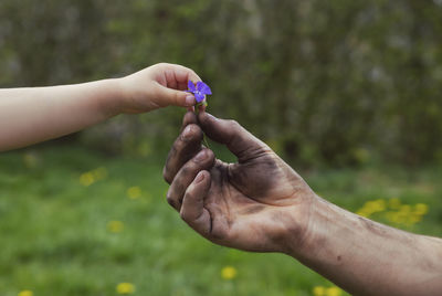 Father, dirty after work, gives his daughter a flower