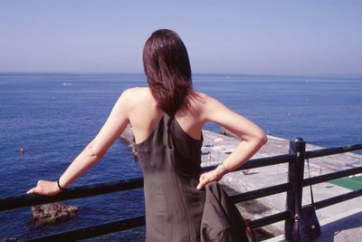 Rear view of woman looking at sea against sky