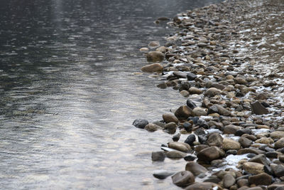 High angle view of pebbles on shore at beach during winter