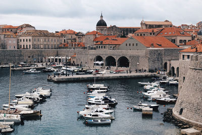 Boats in city against sky