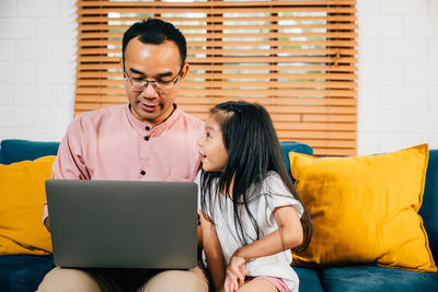 Young woman using laptop while sitting at home