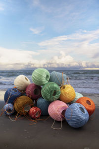 Multi colored umbrellas on table at beach against sky