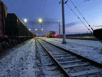 Train in railroad tracks against sky during winter