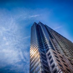 Low angle view of modern building against blue sky