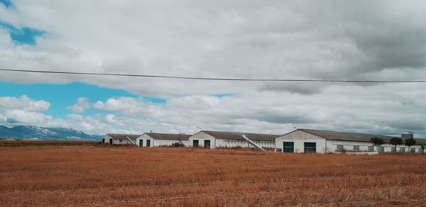 Houses on field against sky