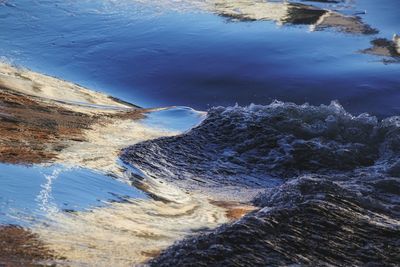 High angle view of sea by mountain against sky