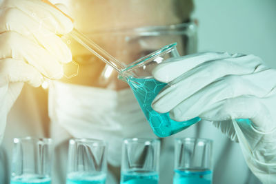 Digital composite image of man examining chemical in laboratory