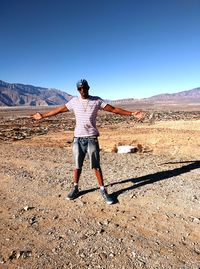 Full length of woman standing on landscape against clear sky