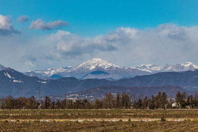 Scenic view of field and mountains against sky