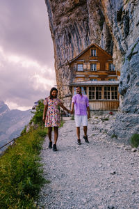 Woman walking on building against mountain